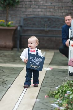 a little boy holding a sign that says has anyone seen the ring?