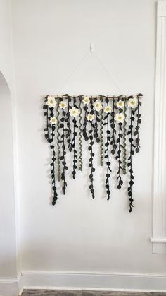 a wall hanging with flowers on it in a white walled room next to a radiator