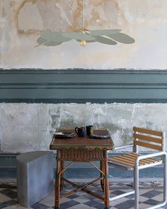 two chairs and a table in front of a painting