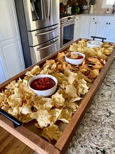 a wooden tray filled with chips and salsa