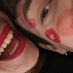 two people with painted on their faces and one has a toothbrush in his mouth