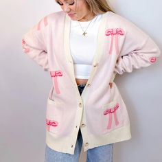 Stay Cozy And Chic With Our Oversized Bow Cardigan. Crafted From Soft, Luxurious Knit Fabric, This Cardigan Features An Effortlessly Elegant Bow Design Throughout , Adding A Touch Of Femininity To Your Look. With Its Relaxed Fit And Versatile Style, It's Perfect For Layering Over Your Favorite Tops For A Polished Yet Comfortable Ensemble. Whether You're Lounging At Home Or Stepping Out For A Casual Outing, This Cardigan Is Sure To Keep You Stylishly Snug All Day Long. Features - Front Buttons - Trendy Pink V-neck Outerwear, Cozy Pink V-neck Outerwear, Pink Oversized Casual Sweater, Chic Oversized Pink Sweater, Casual Oversized Pink Sweater, Pink V-neck Trendy Outerwear, Oversized Trendy Pink Cardigan, Pink Oversized V-neck Sweater, Oversized Pink V-neck Sweater