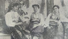 an old photo of three women sitting next to each other in front of a tree