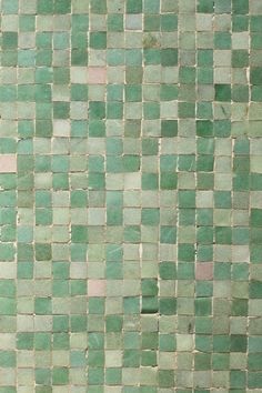 a bathroom with green tiles on the wall