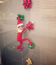 an elf is hanging on the wall next to presents