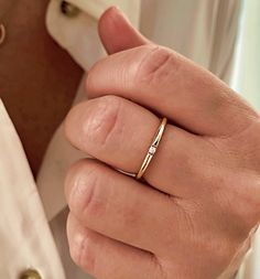 a close up of a person wearing a ring on their finger and holding something in his other hand