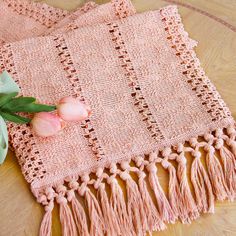 pink tulips are sitting on a table next to a crocheted doily