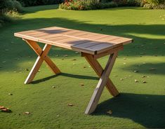 a wooden table sitting on top of a lush green field