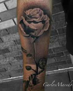 a black and white rose tattoo on the arm