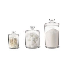 three glass canisters filled with different types of sugar and other things in them