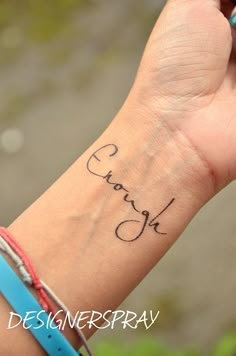 a person's wrist with a small tattoo on it that reads, thank you