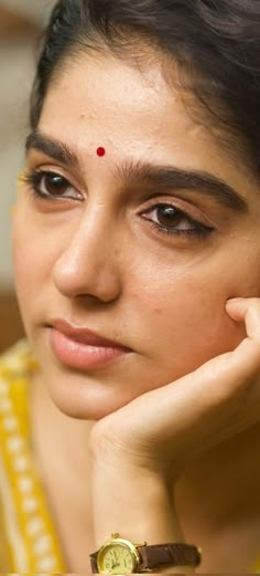 a close up of a person with a watch on her wrist and wearing a bracelet