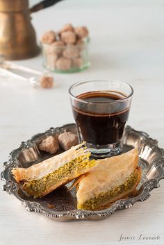 a plate with some food on it next to a cup of coffee