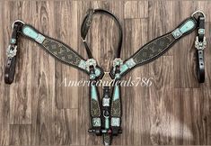 a pair of western style tacks with turquoise and black accents on wood flooring