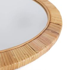 a round mirror made out of wicker on a white background