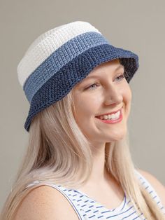 a woman with blonde hair wearing a blue and white crochet beanie hat