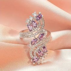 This stunning asymmetrical ring from Barbie Brides is the perfect gift for any occasion. The pear-shaped, lab-created amethyst stone shines beautifully in the white gold-plated copper setting, surrounded by excellent cut-grade cubic zirconia stones. The ring is nickel-free and features a bohemian-inspired design, making it both beautiful and comfortable to wear. Whether you're looking for an engagement ring, a Mother's Day gift, or a special Valentine's Day surprise, this luxury amethyst ring is sure to impress. Its purple and silver color scheme is both elegant and eye-catching, while its unique features make it a one-of-a-kind piece of fashion jewelry. Turkey Jewelry, Pretty Engagement Rings, Jewelry Purple, Rings Women, Gadgets To Buy, Cool Gadgets To Buy, Cubic Zirconia Rings, Zircon Ring, Copper Rings