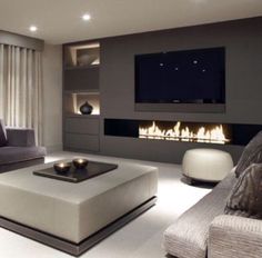 a modern living room with fireplace and couches in front of the television screen on the wall