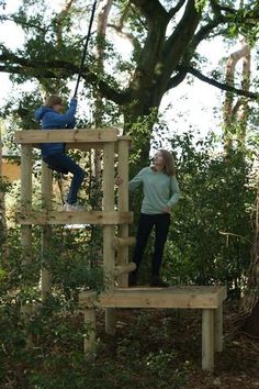 two people on a wooden structure in the woods