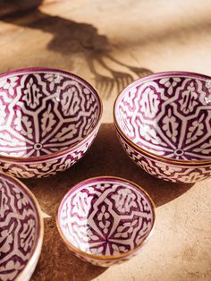 four purple and white bowls sitting on top of a table