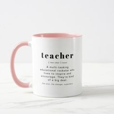 a pink and white coffee mug with the words teacher written in black ink on it