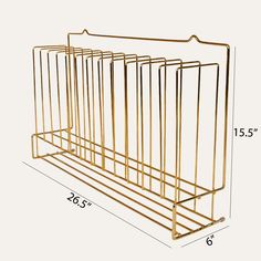 the gold metal magazine rack is shown with measurements for each section, and it has five sections