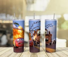 three disney cars tumblers sitting on top of a wooden table