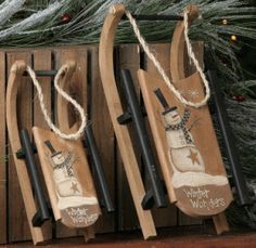 three wooden sleds with snowmen on them