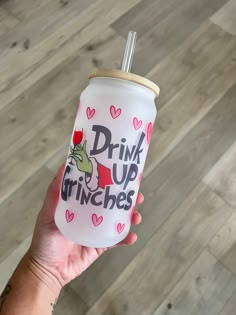 a person holding up a pink drink with the words drink up gringies on it