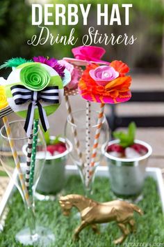 the drink stirrers are decorated with paper flowers and strawberries in vases