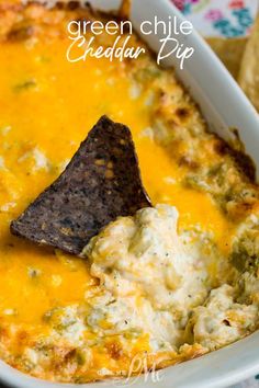 green chile cheddar dip in a white casserole dish with tortilla chips