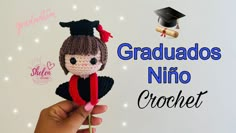 a hand holding a crocheted doll with graduation cap and gown on it's head