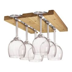 four wine glasses hanging from a wooden rack