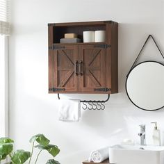 a bathroom with a sink, mirror and wooden cabinet above the toilet paper dispenser