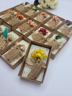 several boxes with dried flowers in them sitting on a table next to some other items