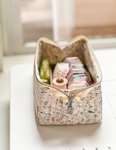 an open purse sitting on top of a white table next to a ruler and window