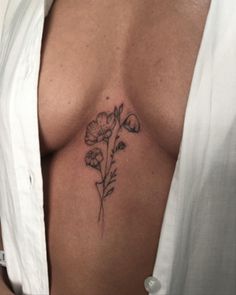 a close up of a person with a flower tattoo on their chest and breast area