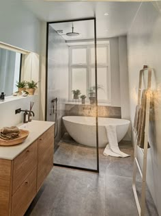 a bathroom with a tub, sink and mirror