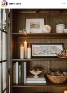 a book shelf filled with books and candles