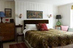 a bed sitting in a bedroom next to two lamps on either side of the bed