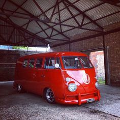 an old vw bus is parked in a garage with brick walls and exposed ceilings