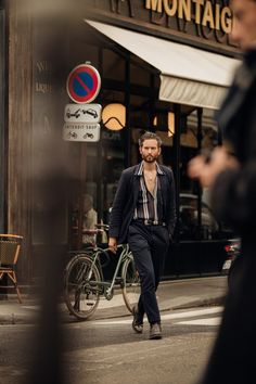 a man walking down the street in front of a building