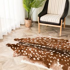 a chair sitting on top of a hard wood floor next to a rug covered in white and brown spots