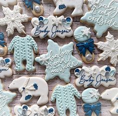 baby shower cookies decorated with blue and white icing on a wooden surface, including snowflakes