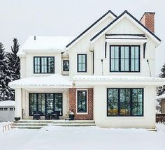 a large white house with lots of windows and snow on the ground in front of it