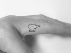 a small elephant tattoo on the middle finger