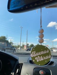 a car dashboard with a sign hanging from it's dash board that says buenos vibrado