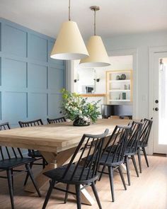 an image of a dining room setting with blue walls and wood table in the center