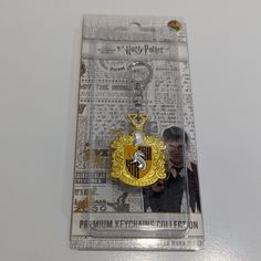 a harry potter keychain with a hogwarts crest on it's front