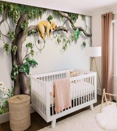 a baby's room decorated in white and pink with a mural of a lion on the wall